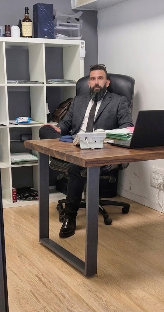 עו״ד עופר טל יושב ליד שולחן העבודה