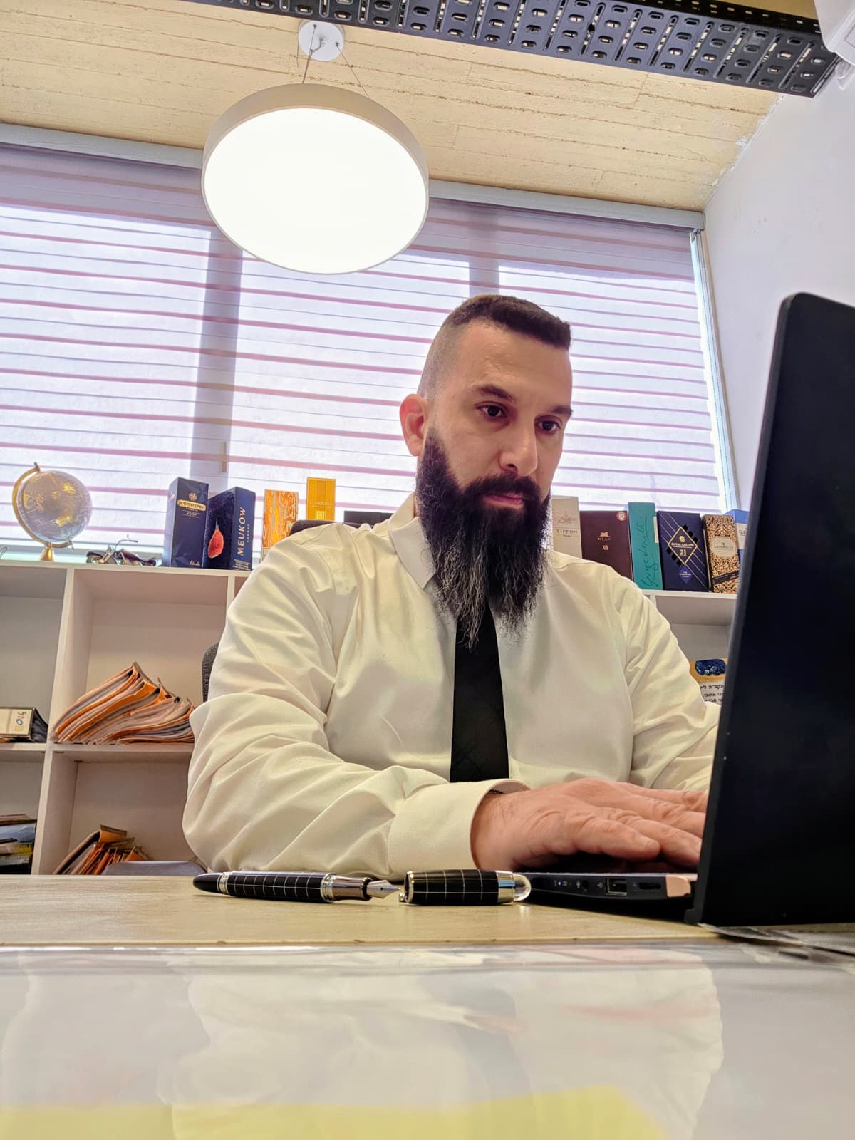עו״ד עופר טל עובד ליד שולחן